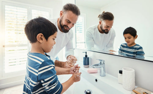 Father washing hands with son