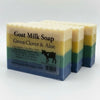 Three bars of goat milk soap with visible layers and a label on a white background