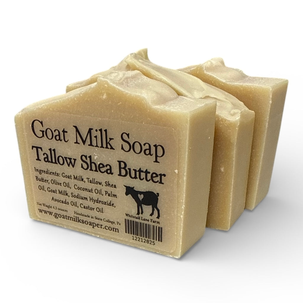 Three bars of tallow Shea butter goat milk soap with a label on a white background